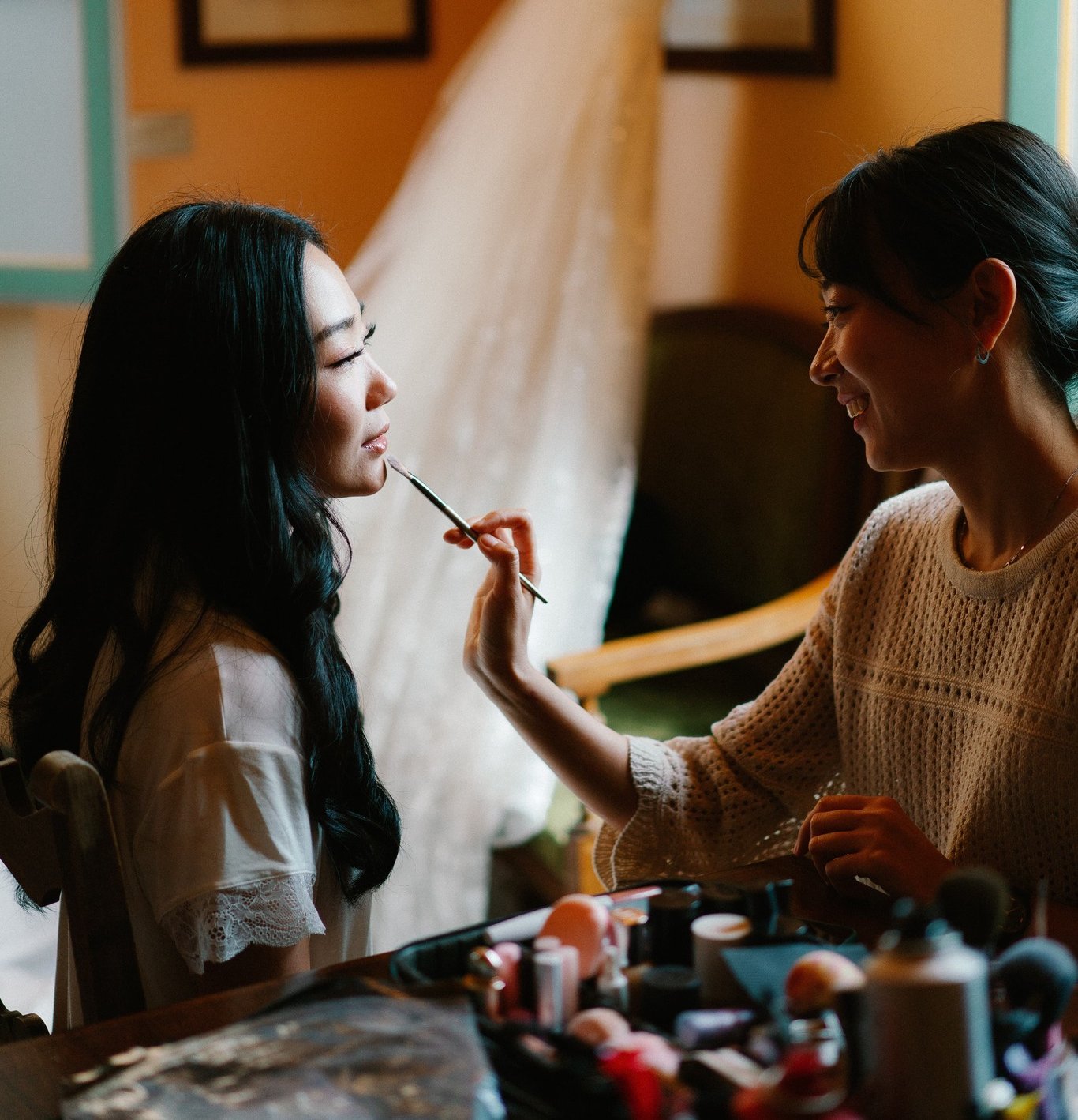 Charlane Yu drawing makeup with a brush on a bride